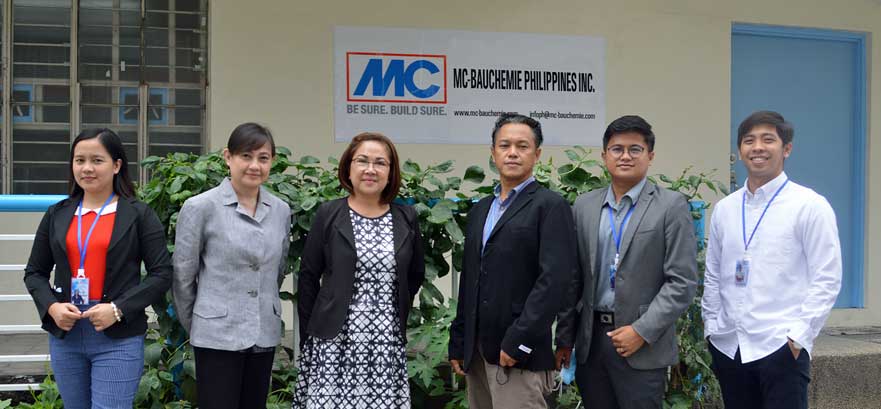 Foto de grupo del equipo de MC-Bauchemie Philippines Inc. con la directora general Shirley Laurel (tercera desde la izquierda) frente al edificio de la empresa en Manila.
