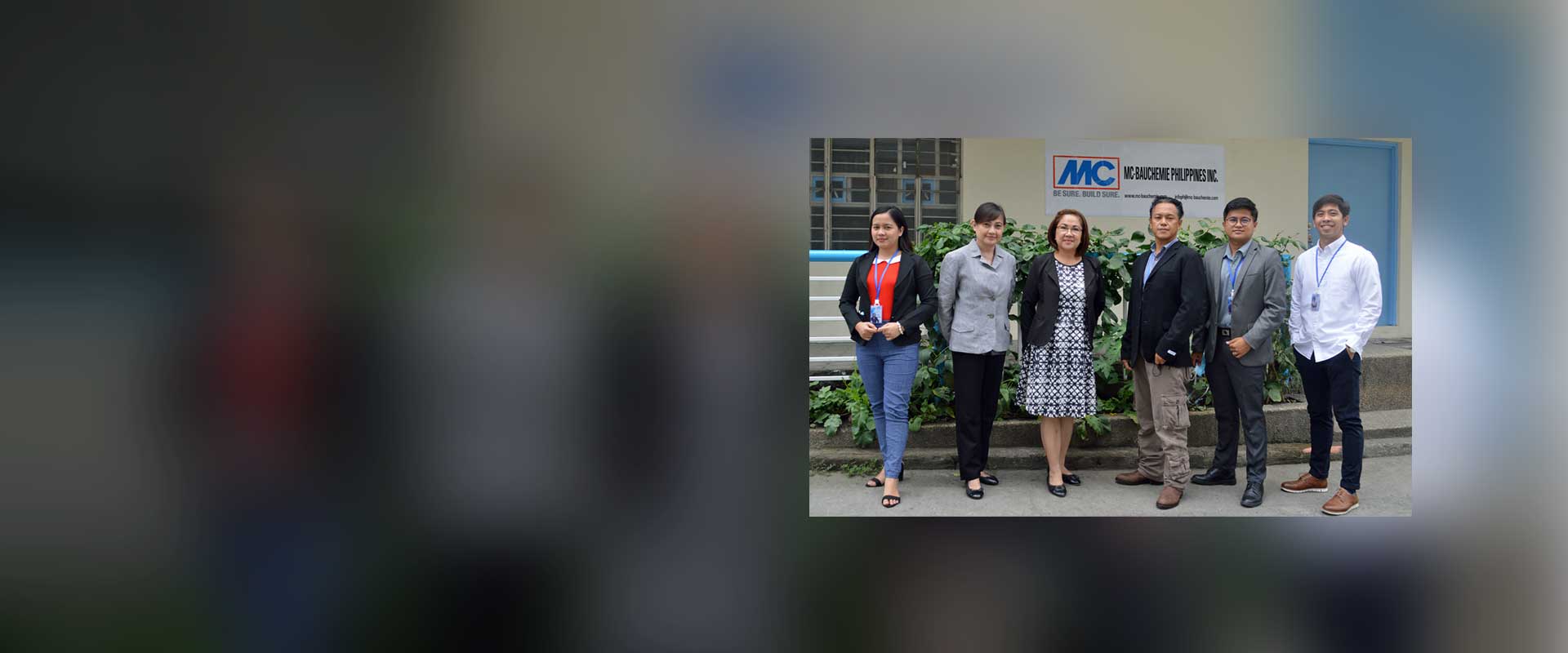 Foto de grupo del equipo de MC-Bauchemie Philippines Inc. con la directora general Shirley Laurel (tercera desde la izquierda) frente al edificio de la empresa en Manila.